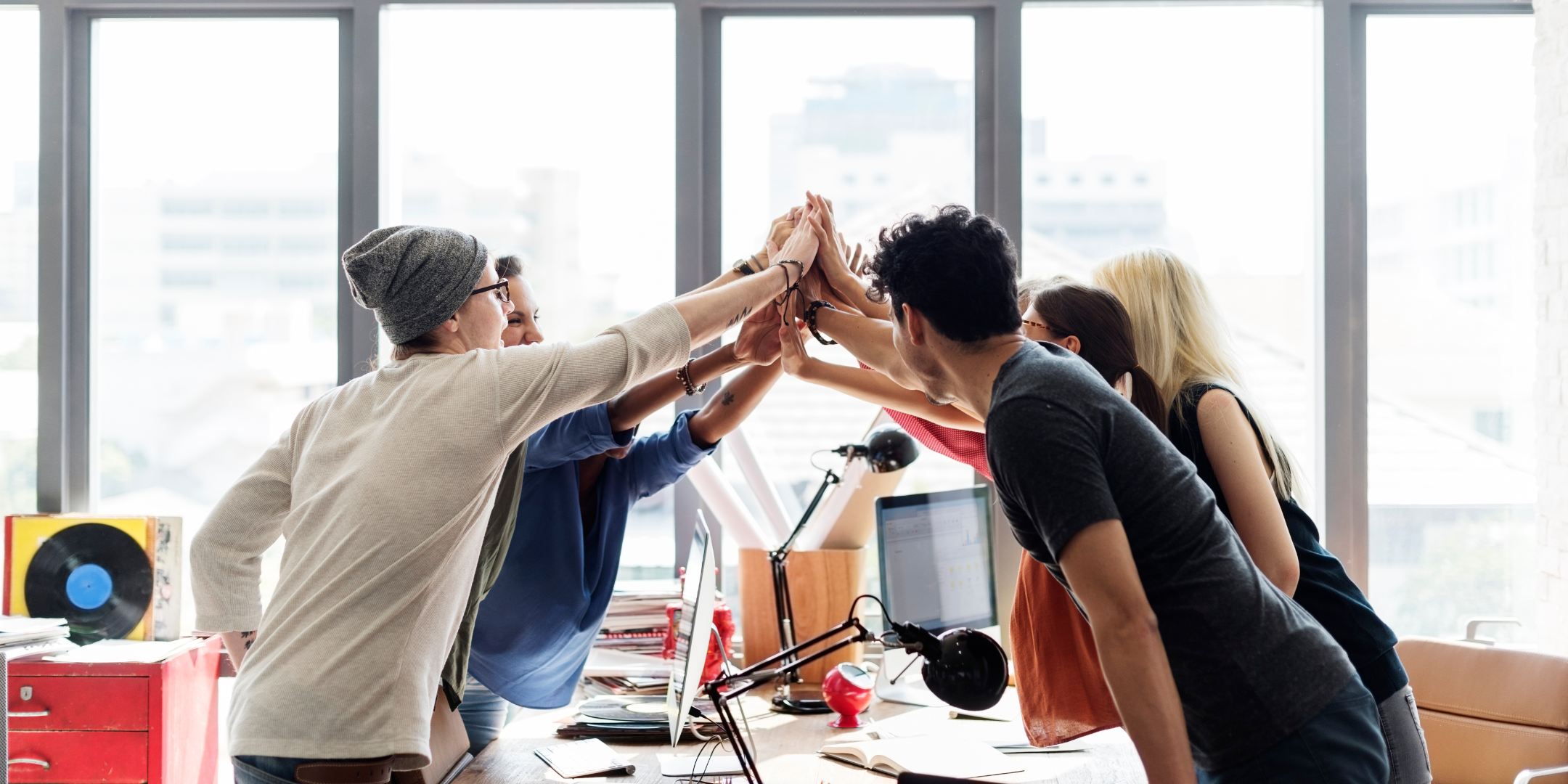 a group of people in an office giving each other high fives